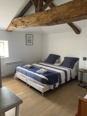 Un dormitorio con cama, mesita de noche y ventana.