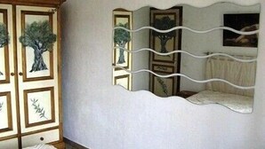 A bedroom with a bed, a wardrobe, and a wall-mounted mirror with tree designs. - 400m to the center of Uzès, appartment for 4 people (Uzès)