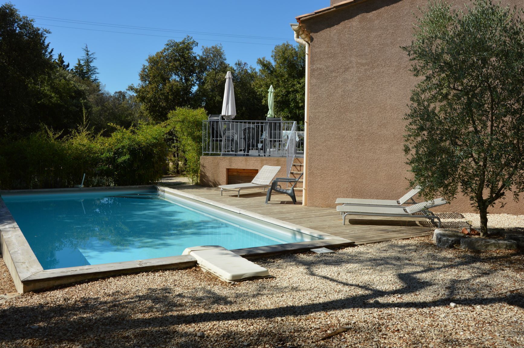 A swimming pool with lounge chairs and a pergola.