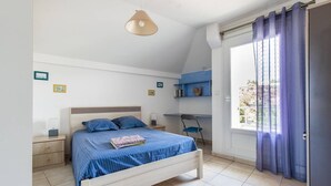 Une chambre à coucher avec un lit, des tables de chevet, un bureau et une chaise.