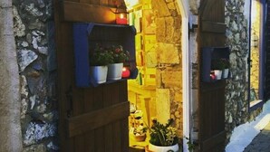 Un bâtiment en pierre avec des portes en bois et une petite cour.