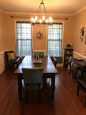 Enjoy meals with family and friends in this spacious dining room, featuring a long table and comfortable seating for six.