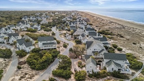 Une zone résidentielle côtière comprenant des maisons, une plage et une route.