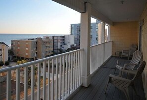 Enjoy the ocean view from this balcony with comfortable seating.