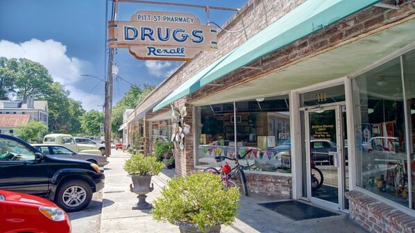 A brick building with a sign for a pharmacy named 'Pitt St. Pharmacy Drugs.'