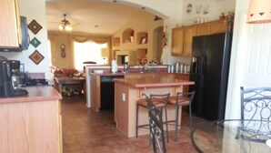 A kitchen with a central island, bar stools, and a glass table. - Golf ... Bird Watching, Biking, Hiking, Sunsets, Star Gazing ... Oh, great Golf (Green Valley)