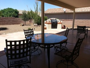 A covered patio with a round glass table and six metal chairs. - Golf ... Bird Watching, Biking, Hiking, Sunsets, Star Gazing ... Oh, great Golf (Green Valley)