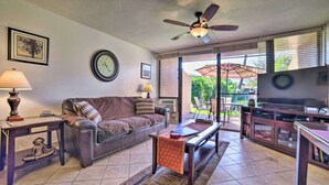 A living room with a sofa, coffee table, TV, and a ceiling fan. - Maui Vista #2110 - Ground Floor! REDUCED RATES! BEDROOM AC, near beach!! (Kihei)