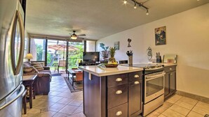 A modern kitchen with a central island, a dining area with a table and chairs, and a living room with a sofa. - Maui Vista #2110 - Ground Floor! REDUCED RATES! BEDROOM AC, near beach!! (Kihei)