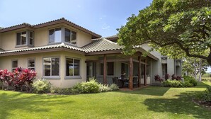A two-story house with a covered patio, a lawn, and various plants. - Views, Views, Views Chef's Kitchen, Ample Supplies, Home Office, Weekly Discount (Kamuela)