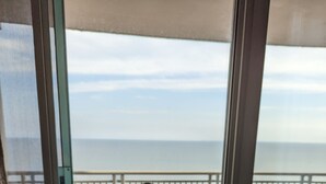 A balcony with a table and chairs, overlooking the sea. - Top Floor Legacy Penthouse / Stunning Gulf Views / Walk to Beach, Pools & more! (Gulfport)