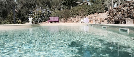Alberca al aire libre y camastros