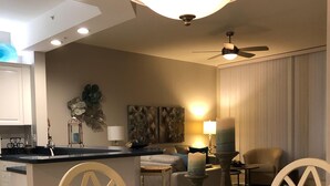A dining area with a glass table surrounded by chairs, a chandelier, and a ceiling fan. - Naples Vanderbilt Beach-beautiful Updated-walk to the beach (Naples)