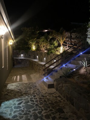 A stone pathway leading to a wooden staircase with a stone wall and greenery. - every morning turn your dream into reality in front of Pinel Island (SAINT MARTIN)
