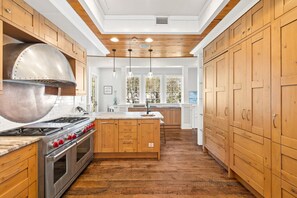 Une cuisine avec des meubles en bois, une hotte en acier inoxydable et un îlot central.