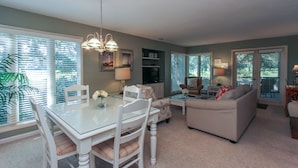 A spacious living room with a dining area, a sofa, and a TV.