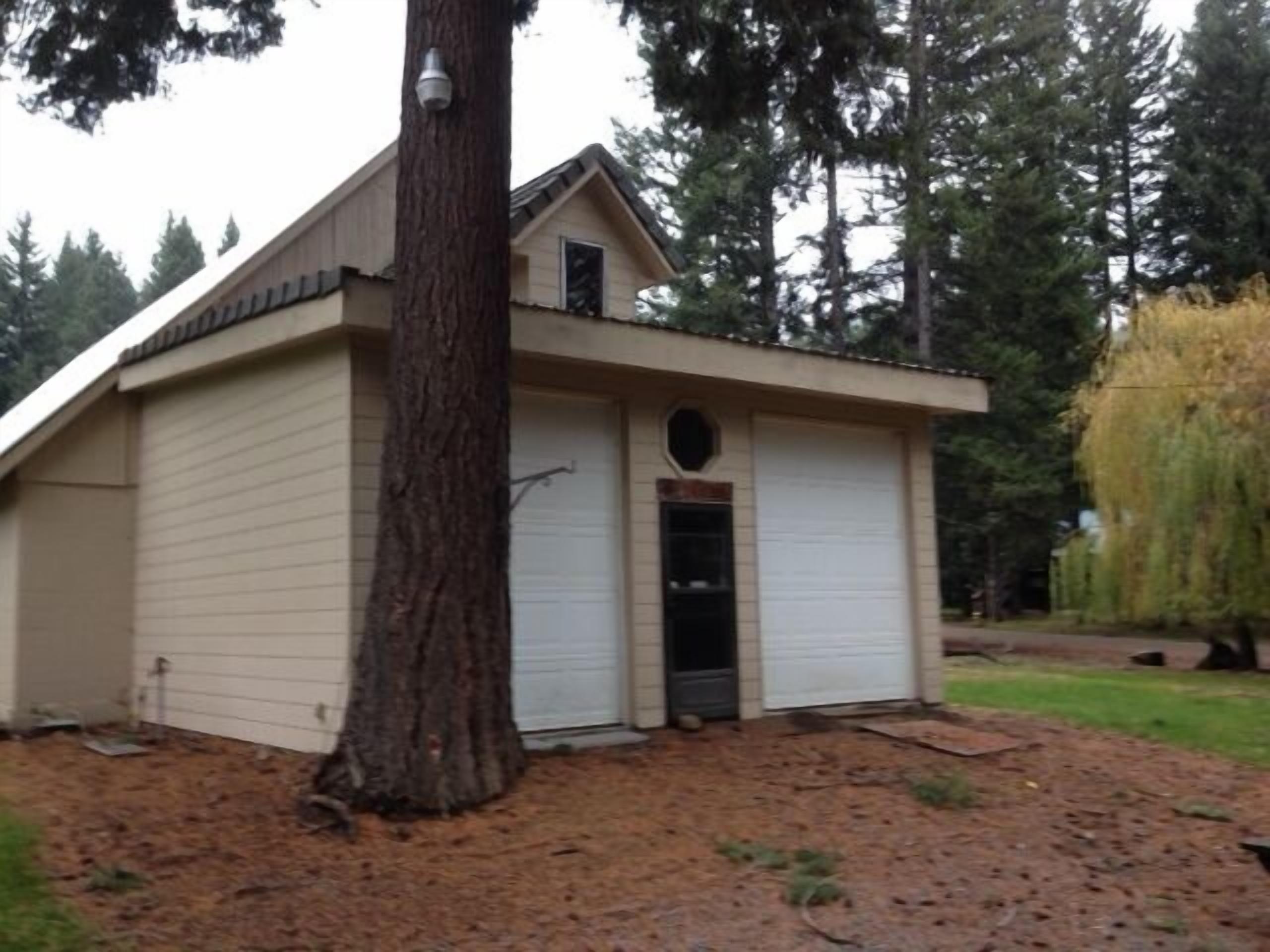 Backside of the cabin.  Garage doors open to a bbq and resin tables and chairs