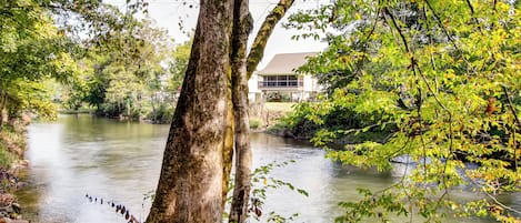 Een rivier met een huis op de achtergrond.