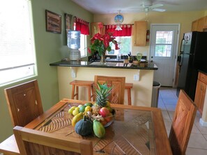 Enjoy meals in this kitchen with a dining table, refrigerator, and water dispenser.