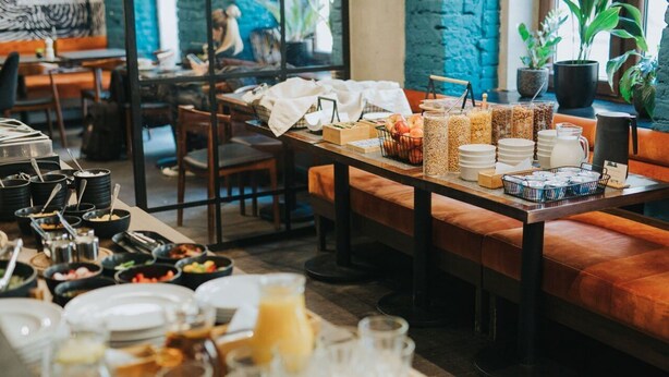 A breakfast buffet setup with various food items and beverages. - Good Time Aparthotel (Lodz)