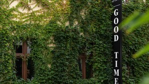 A building with ivy-covered walls and a sign that reads "GOOD TIME". - Good Time Aparthotel (Lodz)