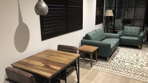 Uma sala de estar moderna com uma mesa de jantar de madeira, dois sofás e um tapete estampado.