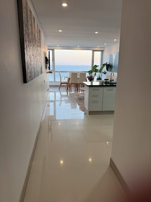 Un intérieur moderne comprenant un coin repas, une cuisine et une vue sur la mer.