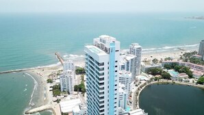 A high-rise hotel with multiple floors, a beach, and a body of water. - Luxury apartment facing the sea (Cartagena)