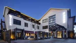 Un hotel moderno con un patio central, ventanas amplias y un acceso cubierto.