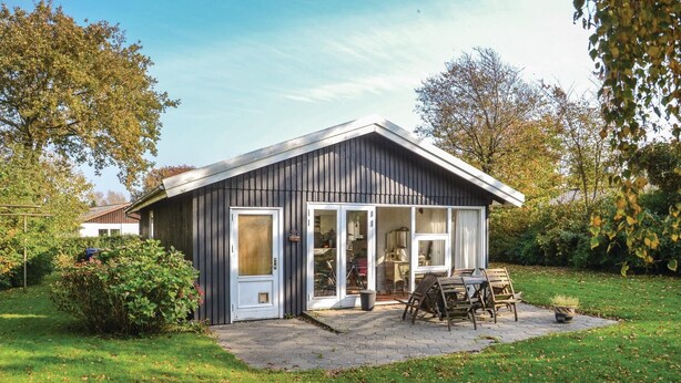 A small, single-story house with a sloped roof and a large sliding glass door. - Nice home in Esbjerg V with WiFi (Esbjerg V)