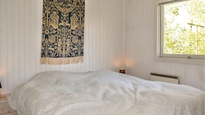A bedroom with a bed, a nightstand, a lamp, and a window with a view of trees. - Nice home in Esbjerg V with WiFi (Esbjerg V)