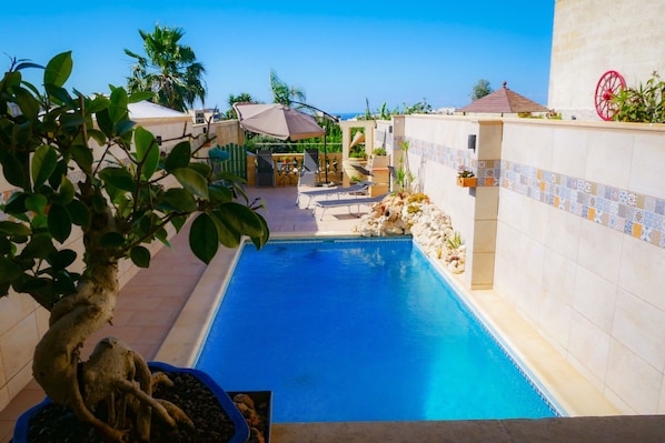 Outdoor pool, open 9:00 AM to 9:00 PM, pool umbrellas, pool loungers