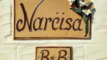 Un letrero con el nombre 'Narcisa' y un letrero más pequeño debajo que dice 'B&B'.