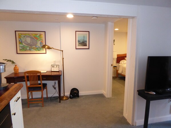 A compact room with a desk, chair, and a TV stand. - PORTHOLE: Peaceful with a private, locked, covered patio to relax/ store bikes. (Port Angeles)