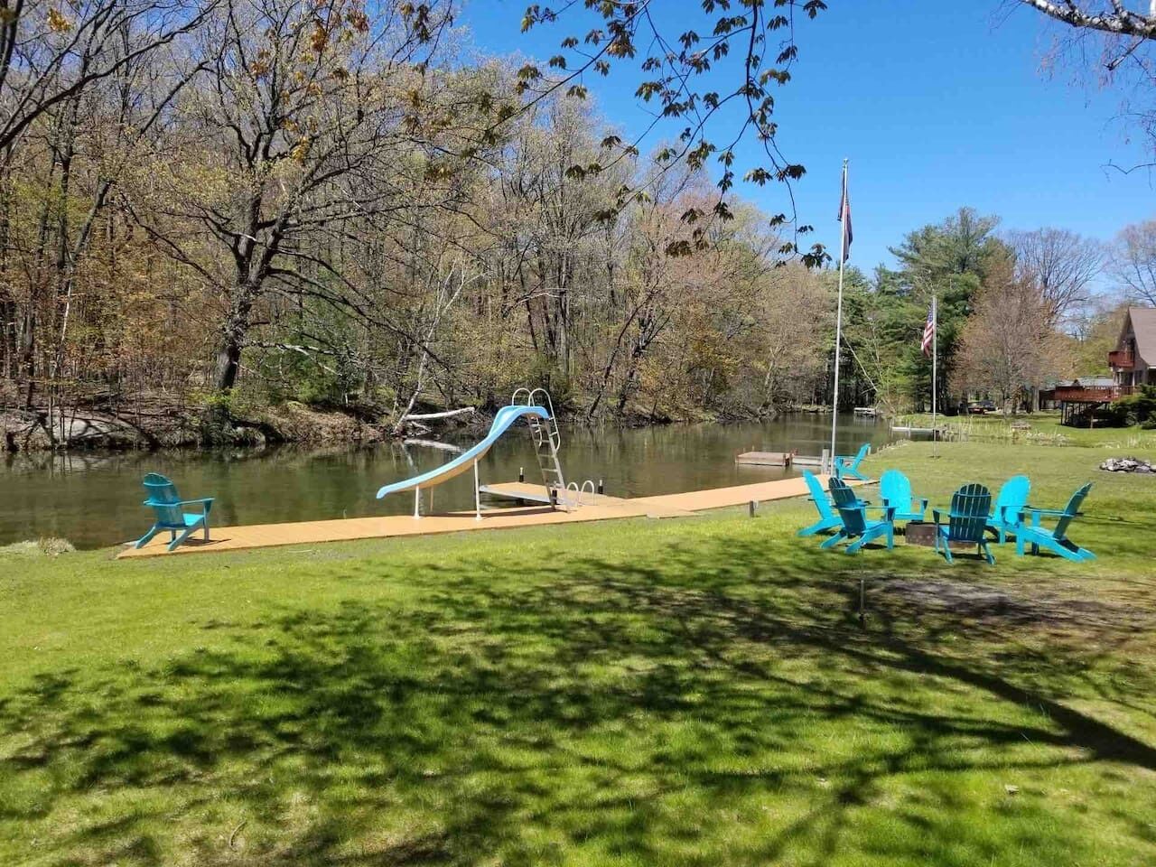 Un parc doté d’une aire de jeux, d’un étang et de fauteuils Adirondack.