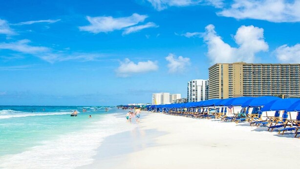 A beach with white sand, clear turquoise water, and a row of blue beach umbrellas. There are high-rise buildings in the background. - SUGAR WHITE SAND! RIGHT ON THE BEACH!! GREAT VIEWS!! FAMILY FUN!!
#1815 DESTIN (Destin)
