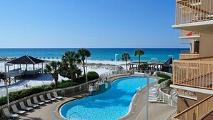 A poolside view with a beach and ocean in the background, a covered seating area, and a building with balconies. - SUGAR WHITE SAND! RIGHT ON THE BEACH!! GREAT VIEWS!! FAMILY FUN!!
#1815 DESTIN (Destin)