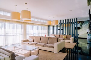 Una sala de estar moderna con un sofá color beige, una mesa de centro e iluminación colgante.