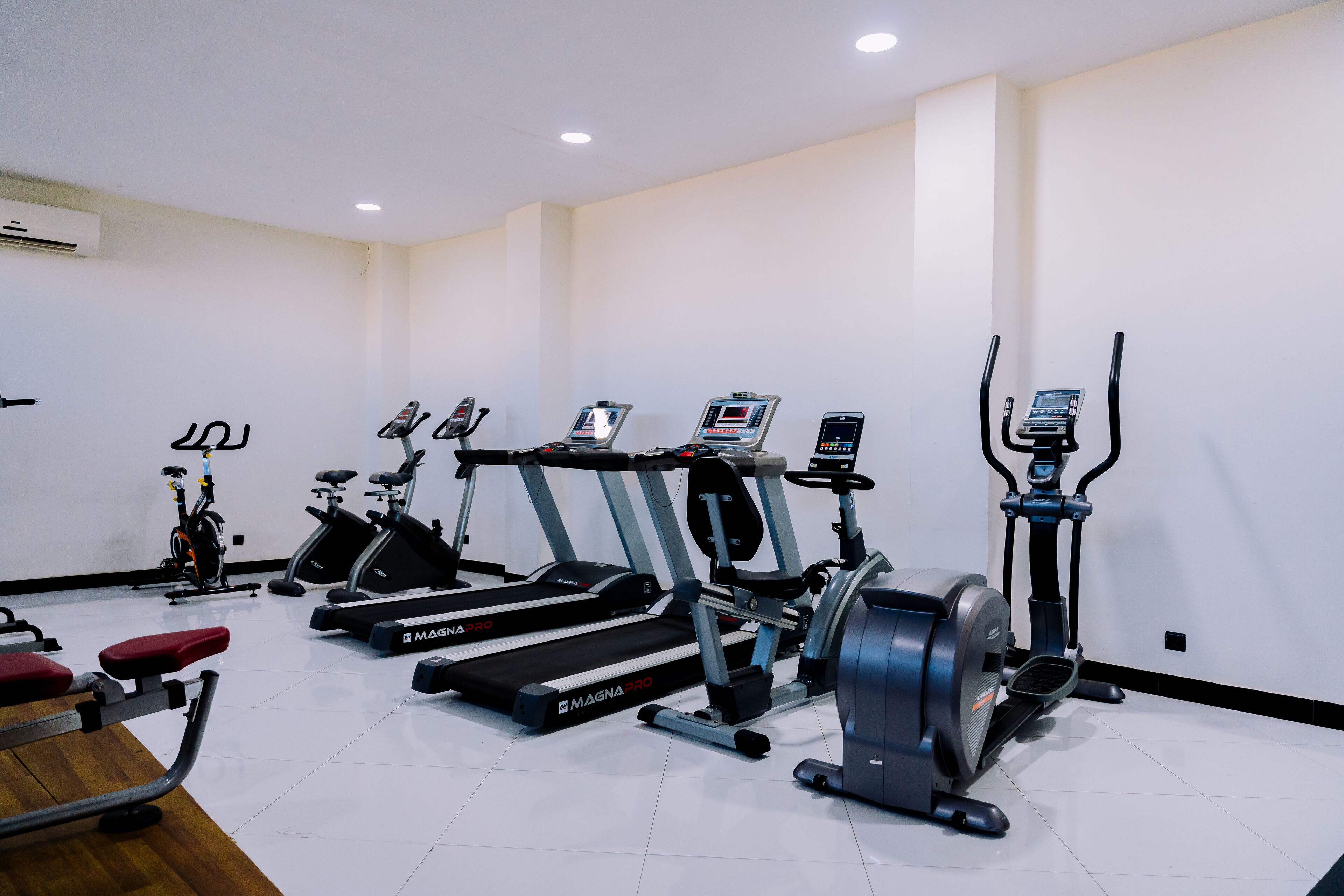 A gym with treadmills, ellipticals, and a stationary bike.