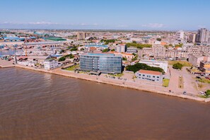 A coastal cityscape with a prominent modern glass building, a marina, and a mix of residential and commercial buildings. - Beira Terrace Hotel (Beira)