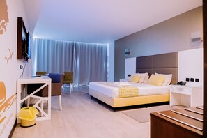 A modern hotel room with a large bed, bedside tables, a TV mounted on the wall, and a view of the outdoors through sheer curtains. - Beira Terrace Hotel (Beira)