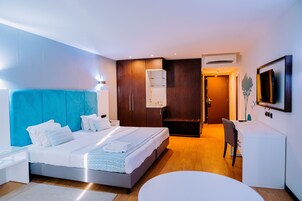 Una habitación de hotel moderna con una cama grande, un escritorio y una zona de estar.