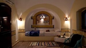 A cozy bedroom with a bed, a chair, and a nightstand. - Al Baeirat hotel (Luxor)