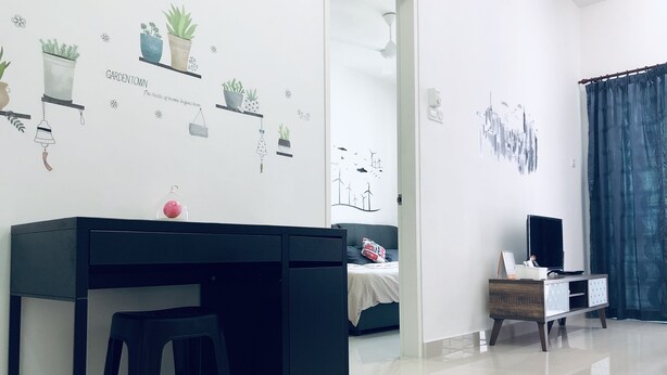 Una sala de estar moderna con un escritorio negro, un sofá blanco y un mueble para televisión.