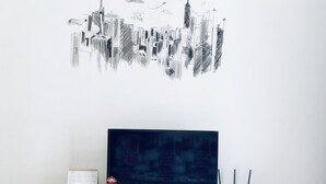 Un mueble moderno de entretenimiento con un televisor de pantalla plana, un altavoz pequeño y una estación de carga.