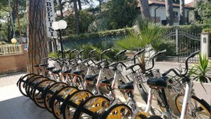 A row of bicycles parked in a designated area with a sign reading "H. BELINI". - Hotel Bellini (Riccione)