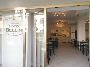 A hotel interior with a dining area, a kitchen, and a visible sign reading "HOTEL BELLIN". - Hotel Bellini (Riccione)