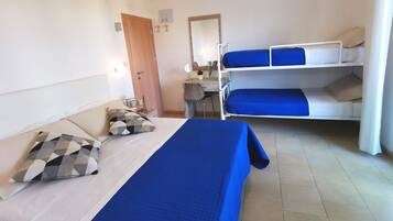 Habitación de hotel con una cama individual, un escritorio, una silla y dos literas.