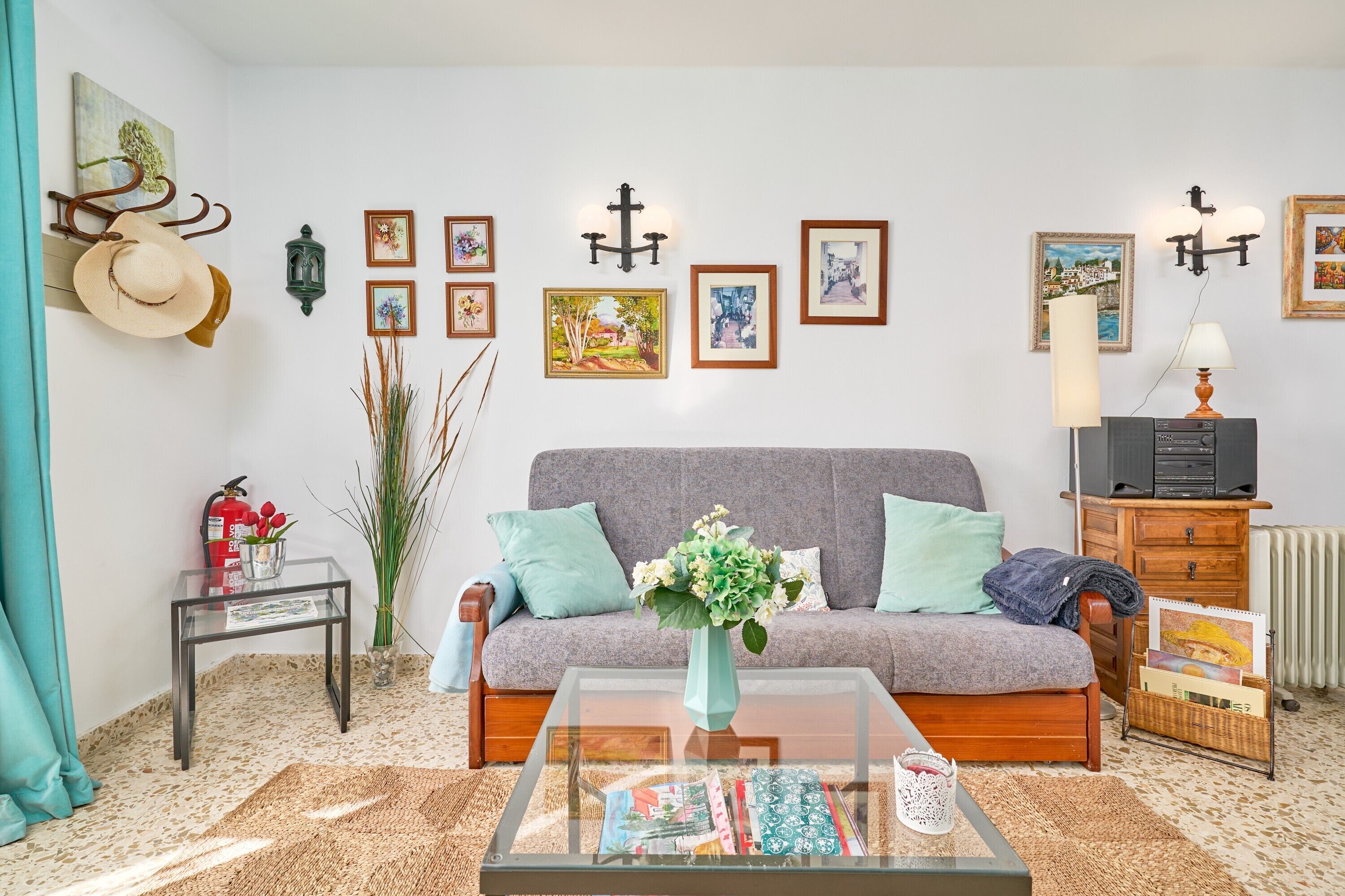 A living room with a sofa, a coffee table, a fireplace, and wall-mounted artwork.