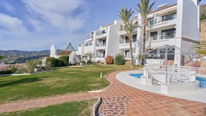 Un hotel moderno con piscina, césped cuidado y vistas del paisaje circundante.